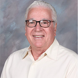 Gary Gregg wearing glasses and a white button shirt