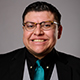 Alberto Mendoza Gonzalez Larreynaga smiling in a three-piece suit.