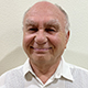 Bruce Schreibfeder smiling, wearing a white shirt.