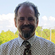 Ken Shafer smiling wearing a shirt and tie.