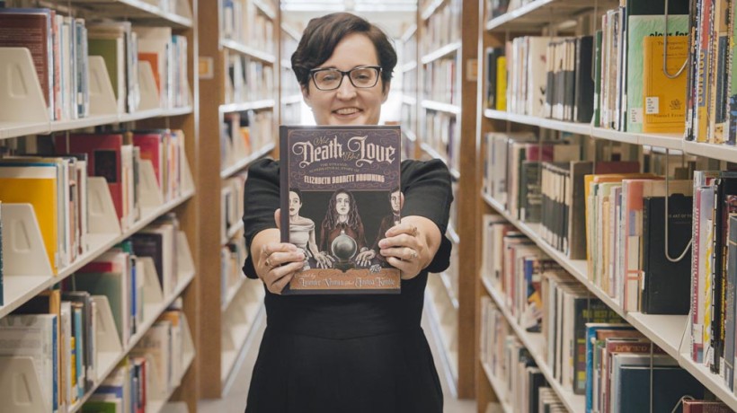 Former AVC student Lavender Vroman holding book titled: Not Death, But Love: The Strange, Supernatural Story of Elizabeth Barrett Browning.