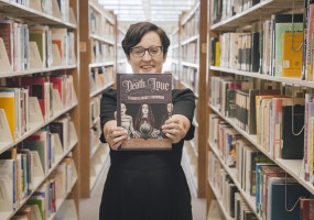 Former AVC student Lavender Vroman holding book titled: Not Death, But Love: The Strange, Supernatural Story of Elizabeth Barrett Browning.